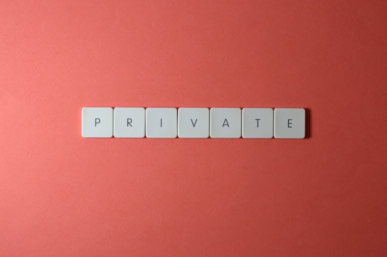 White letter tiles spelling 'PRIVATE' on a red background, offering conceptual minimalist design.